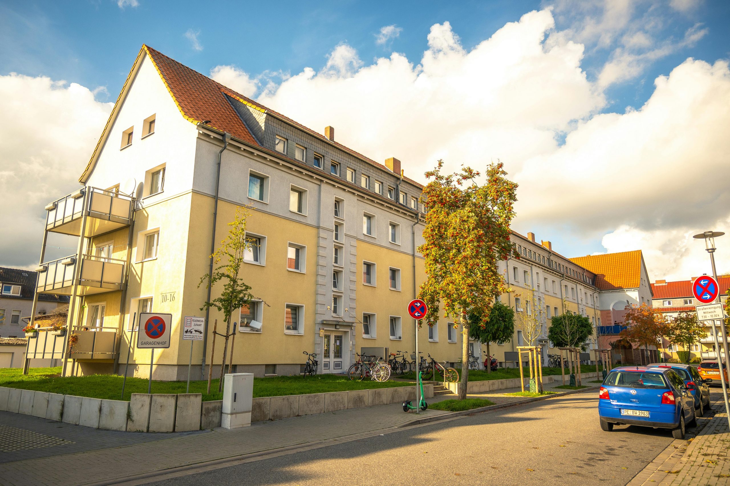 Quaint urban street in autumn with German architecture and vibrant fall colors, captured on a sunny day.